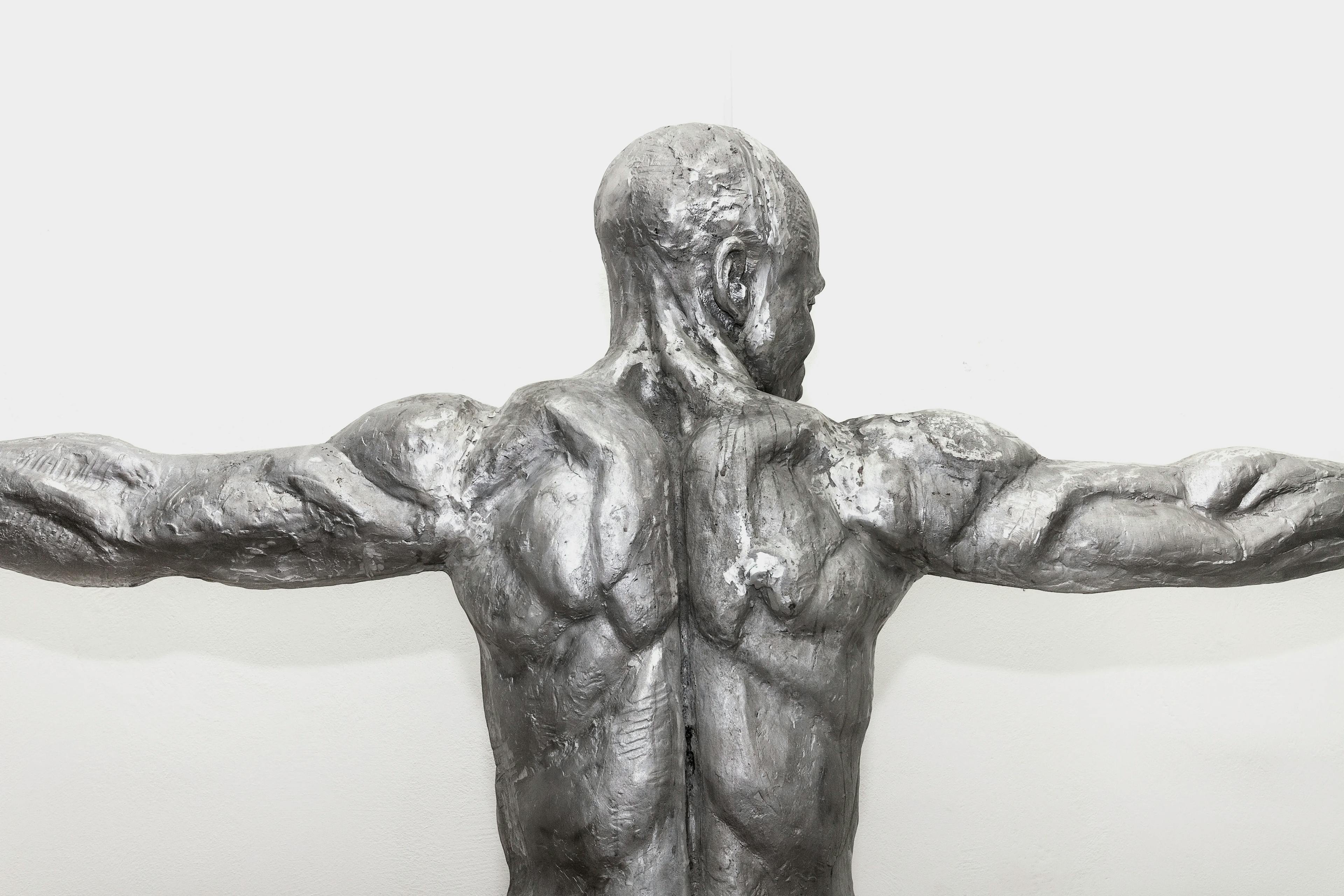 Infinity: a 218 cm tall aluminium sculpture of a Nigerian man crouching with hands outstretched