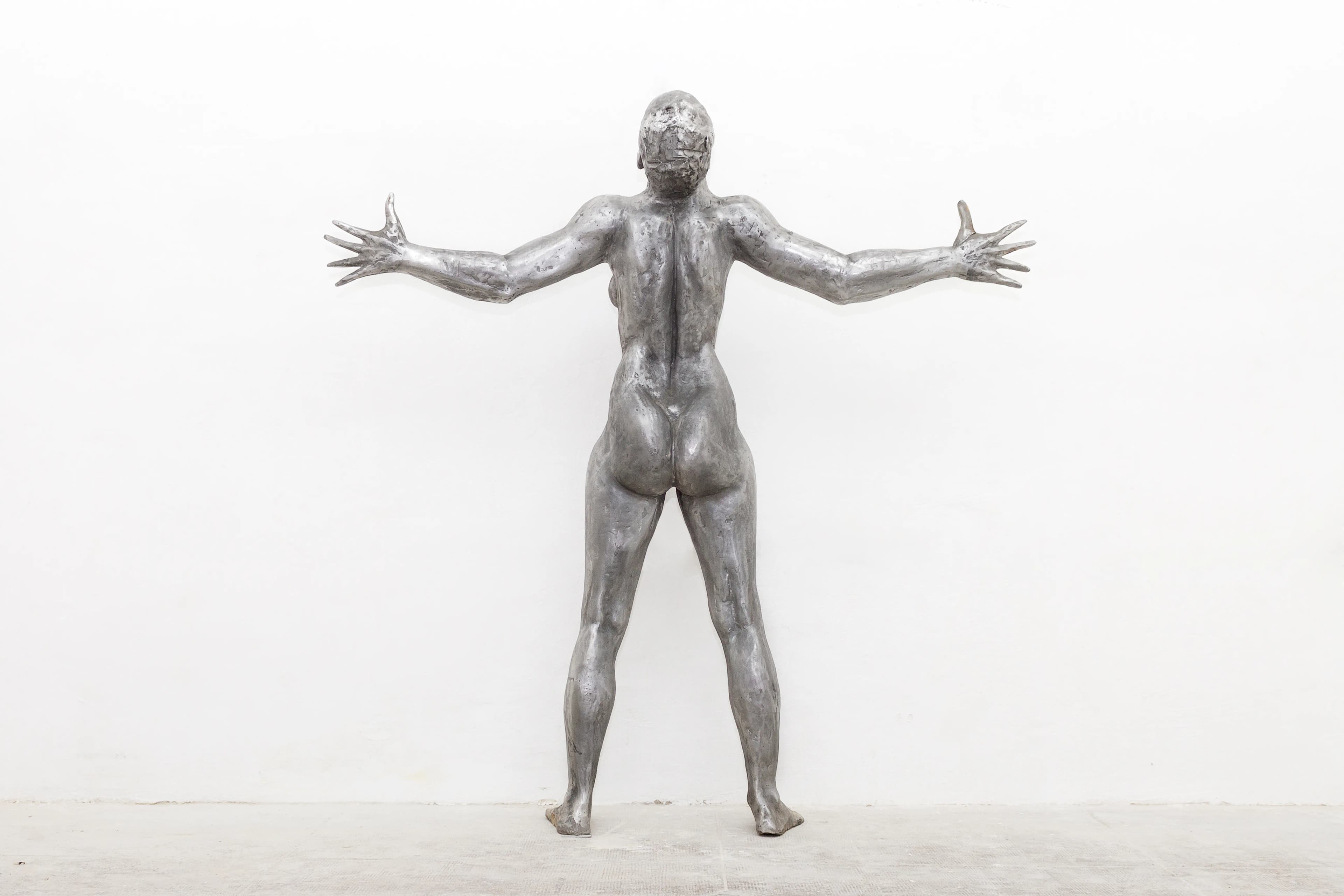 Sacrifice: a 186cm tall aluminium sculpture of a strong, beautiful woman with her hands outstretched