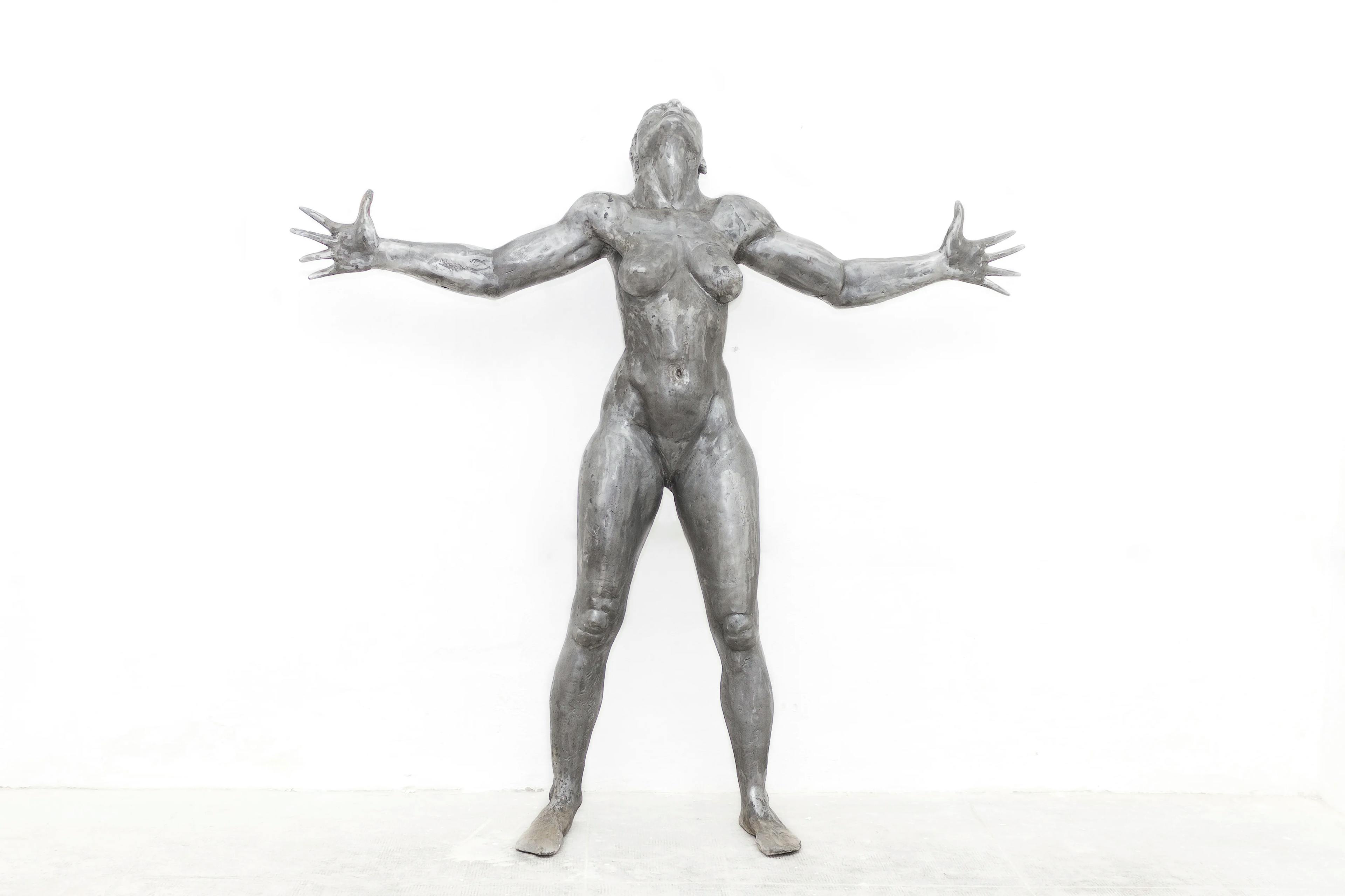 Sacrifice: a 186cm tall aluminium sculpture of a strong, beautiful woman with her hands outstretched
