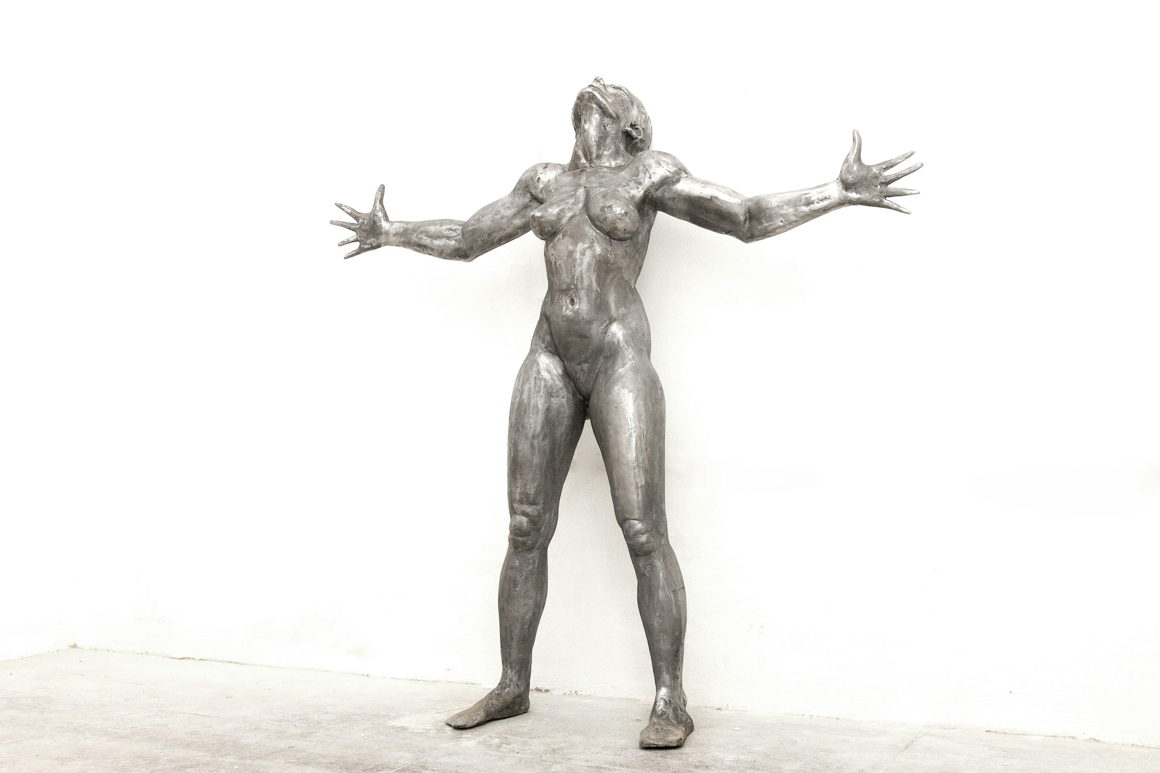 Sacrifice: a 186cm tall aluminium sculpture of a strong, beautiful woman with her hands outstretched