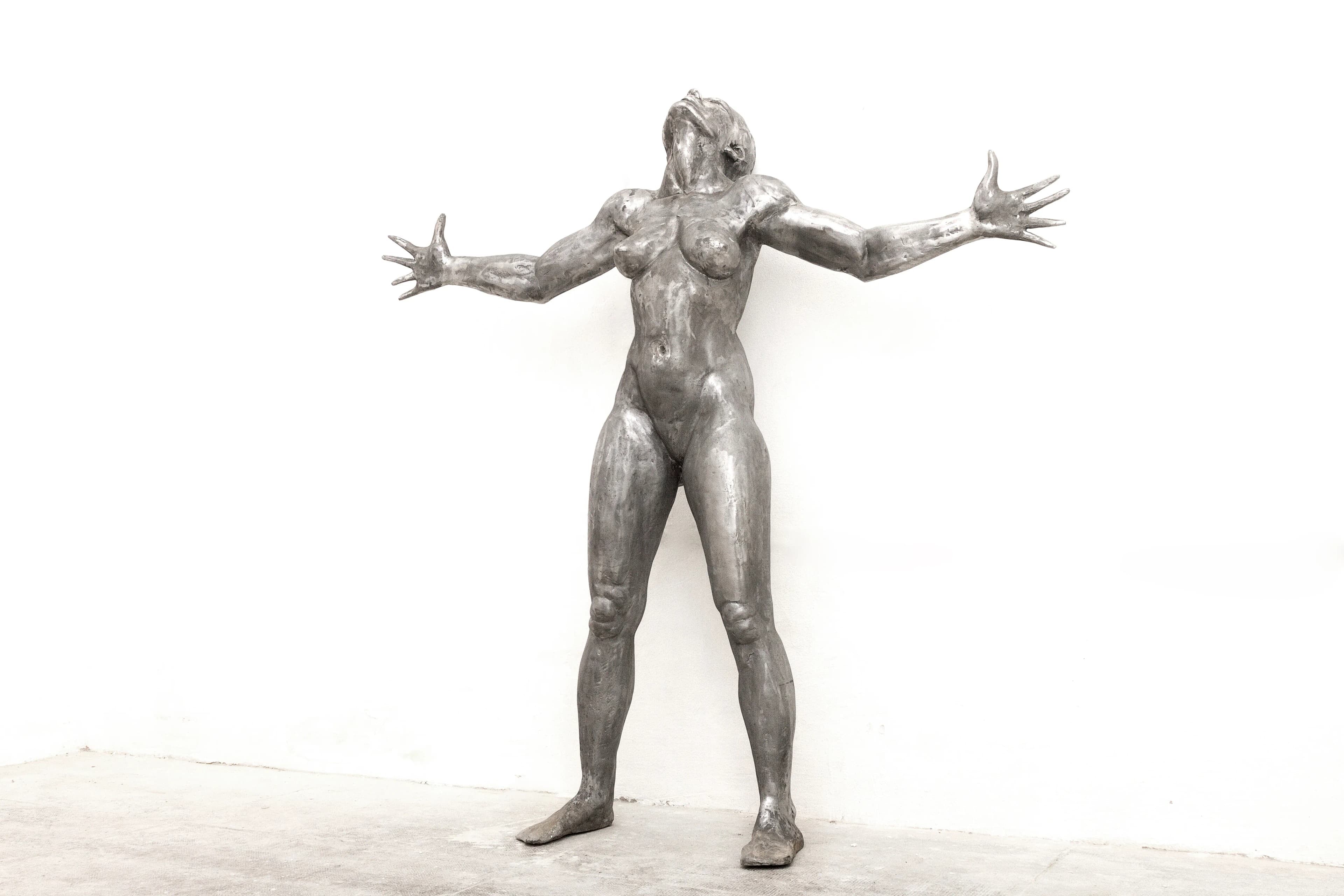 Sacrifice: a 186cm tall aluminium sculpture of a strong, beautiful woman with her hands outstretched