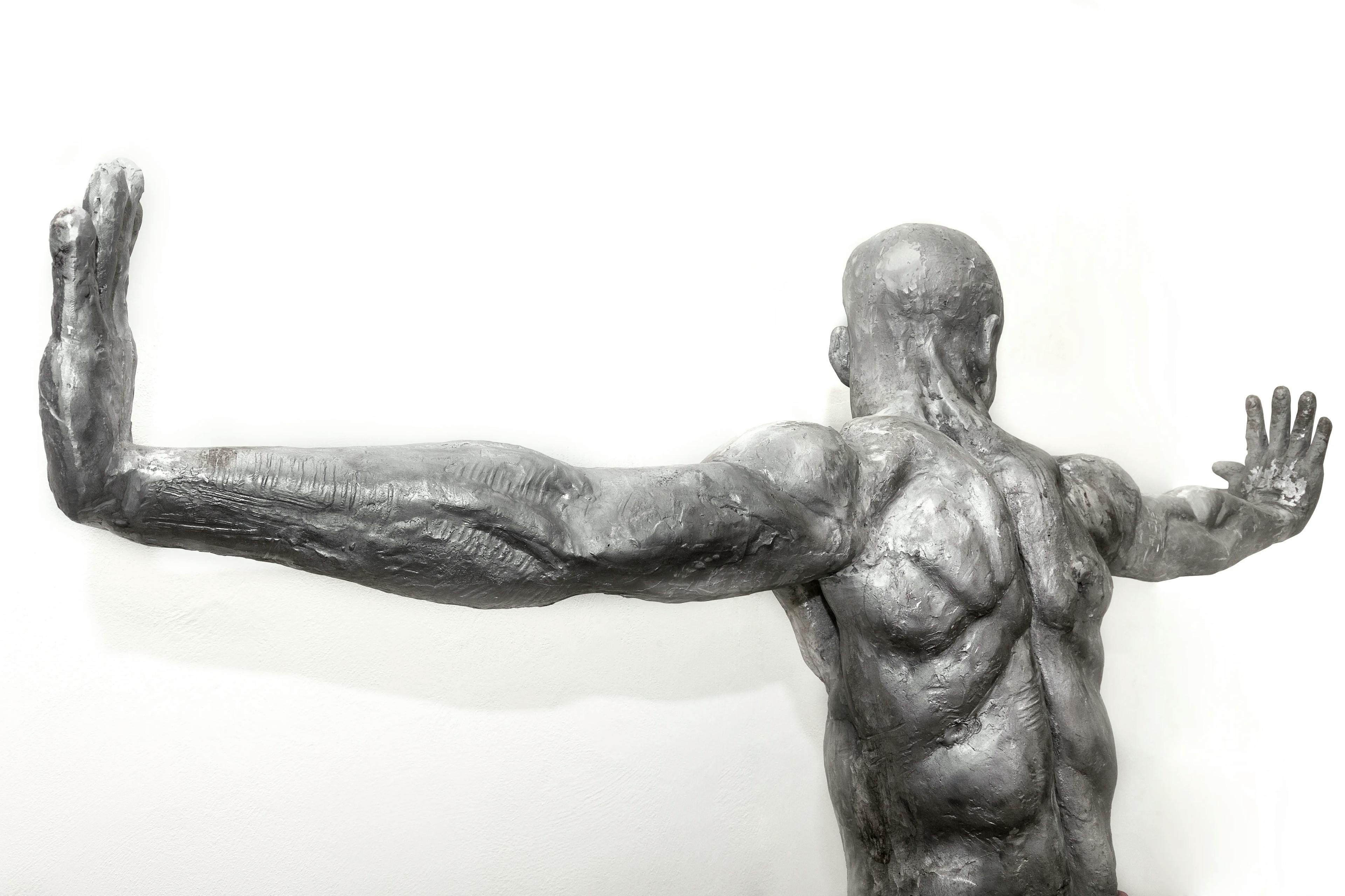 Infinity: a 218 cm tall aluminium sculpture of a Nigerian man crouching with hands outstretched